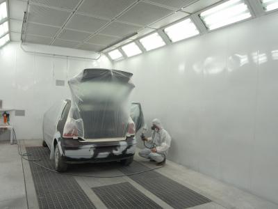 man painting car in spray booth